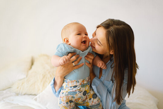 A young mother is play with little baby boy. Mother of a nursing baby. Happy motherhood. The family is at home. Portrait of a happy mother and child.