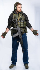 airsoft player in full gear with weapons series GG RK74 fire. a man in an outfit, in headphones, a...