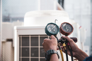 Heat and Air Conditioning, HVAC system service technician using measuring manifold gauge checking...
