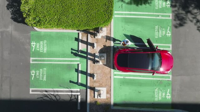 Aerial overhead of guy getting out red modern SUV vehicle with glass moonroof 4K