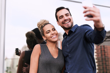 Fototapeta premium World, youll soon get to see our success. Shot of two colleagues taking a selfie together outside an office.