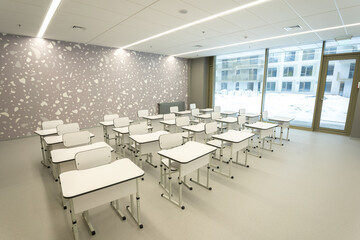 Empty classroom in school or university - chairs and desks without anyone. All room in white colour