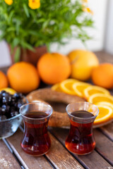 Turkish tea, sesame bagel, oranges and olives on wooden table