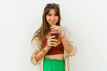 Summer portrait of stylish brunette woman  enjoing sweety lemonade and posing on white background.