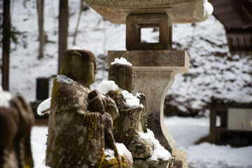 Snow on jizo little buddha statues in Japan