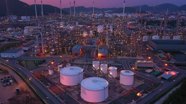 Aerial view at the refinery and oil tank at dusk. Business and petrochemical plants, oil storage tanks and for energy and steel pipes in Twilight time