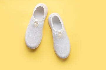 white women's sneakers on a yellow background