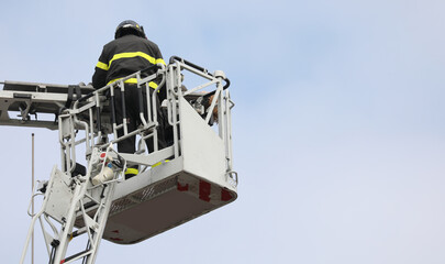 brave firefighter who saves the injured person using the truck with the ladder truck during an...