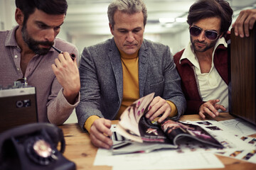Trying to find the perfect concept. Three designers clad in retro 70s wear working on a project...