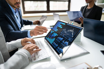 Side View Of Businesspeople Examining Graph On Computer
