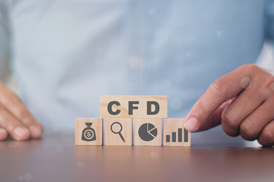 Business man puts the wooden cube with success icon CFD. Contract for difference financce technology stock market concept.