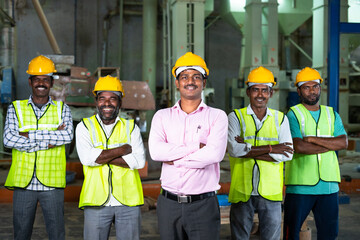industrial employees with crossed arms standing by looking camera at factory - concept of...