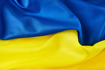 Ukrainian national flag. Blue and yellow colors fabric. Close up shot, selective focus, background