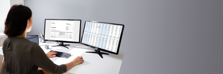 Businesswoman Calculating Invoice On Computer