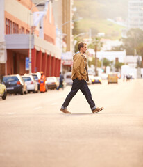 Trendy travels. Full lenth shot of a casually dressed man walking across the street.
