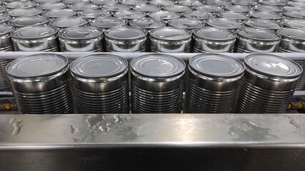 clean cans of milk from conveyor after being washed in the factory