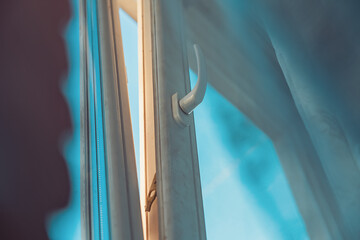 View from below to white plastic open window frame at sunset. Tranquility at home at evening.