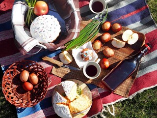 Family picnic with Easter cakes, wine and eggs.Easter feeding on the grass on the lawn in nature.