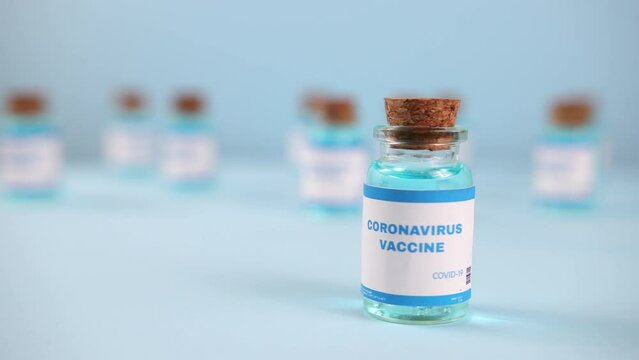 LVIV, UKRAINE - DEC 09, 2020: Syringe needle, a drop liquid, blurred pfizer company on the blue background. Coronavirus vaccine concept. Covid-19 inoculation jointly developed. Ready-made preparations