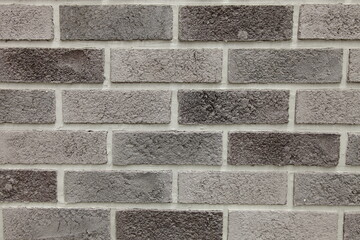Brick wall with worn brick, gray brick background.