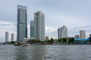 Fototapeta na wymiar Chao Phraya River include modern tower and public boat, It's the major river in Thailand