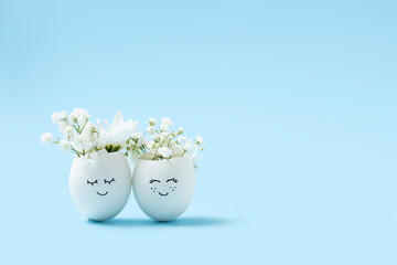 Easter funny decorated eggs stand in a row on blue background. Minimal Happy Easter concept card with copy space for text. 