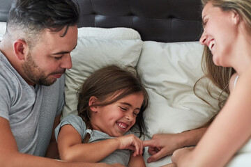 They never miss a day of fun. Cropped shot of a family having fun while lying in bed at home.