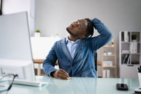 Man Stretching At Office Desk