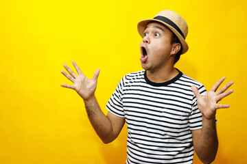 Portrait of Hipster young man young happy man casual dress a hats. Gesture emotion extend the arms shy modest on studio portraits set color yellow background.