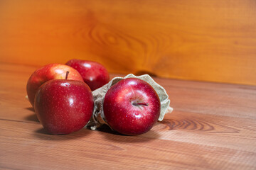 Fresh red apples fell out of storage bags on a wooden background with a place for text: healthy snack, vitamins, healthy food, ingredients for baking recipes