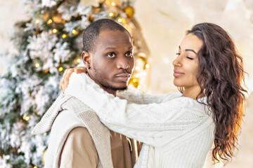A happy couple of mulattoes exchange gifts with each other. Celebrating joint family events. - obrazy, fototapety, plakaty