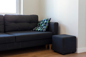 Dark blue sofa with blue and turquoise cushion in a white room