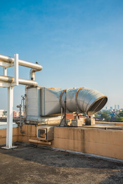 Outdoor large pipe vent ventilation on roof top of building. Ventilation system, industry and technology concept.