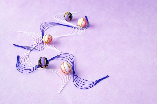 日本のイメージ　波型水引と紫の手まりのデザイン（薄紫の背景）