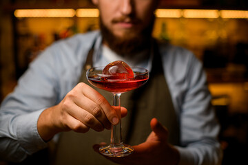 close-up front view of wine glass with ice and drink on male hands