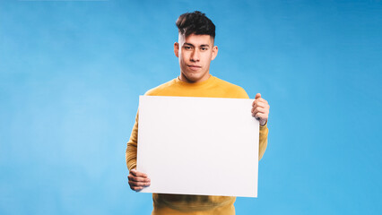 Man looking at camera while holding blank white sign over an isolated background.