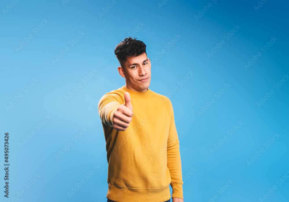 Poster positive man showing thumb up while standing on isolated background.