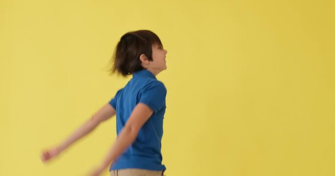 Crazy boy dancing over yellow background