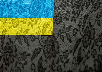 Blue and yellow flag on a black background with lace shadows. Colors of the Ukrainian flag. Place for text. Stand with Ukraine