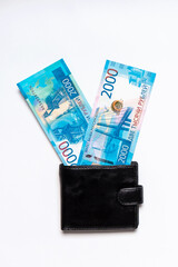 Victory symbol made of new russian money banknotes of two thousand roubles in leather purse on white background. Paper bills in pocketbook. Success in business, finance, wealth concept