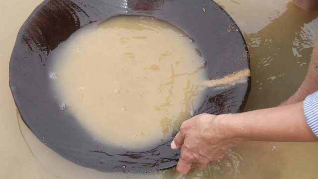  gold particles to settle to the bottom of the pan by vigorously shaking the sediment-water mixture