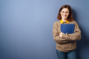 young business woman with cv stands in front of blue background - 495080202