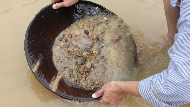  gold particles to settle to the bottom of the pan by vigorously shaking the sediment-water mixture