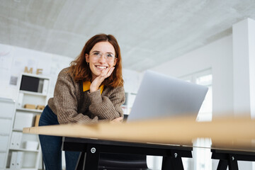 young modern business woman leaning on the desk and laughing - 495080646