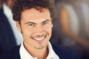 Happy to here and eager to learn. Portrait of a handsome young businessman attending a seminar.