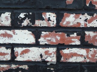 Mur de briques rouges peint en blanc puis en noir