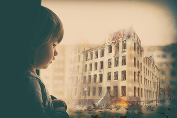 Sad baby girl on the background of the destroyed city. Destruction across Ukraine in the wake of...