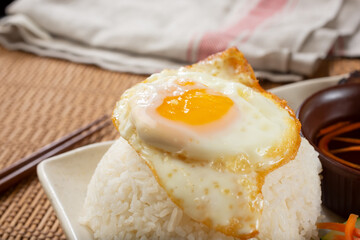 A view of a fried egg on a mound of white rice.