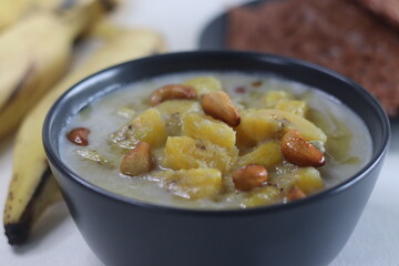 Ripe plantain stew. A sweet curry made of ripe plantain, coconut milk and seasoned with roasted cashews. Served with red rice pancakes