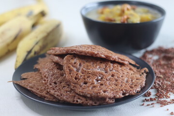 Red rice pancakes. Pancakes made of a fermented batter of red rice and coconut. Served with Ripe plantain stew